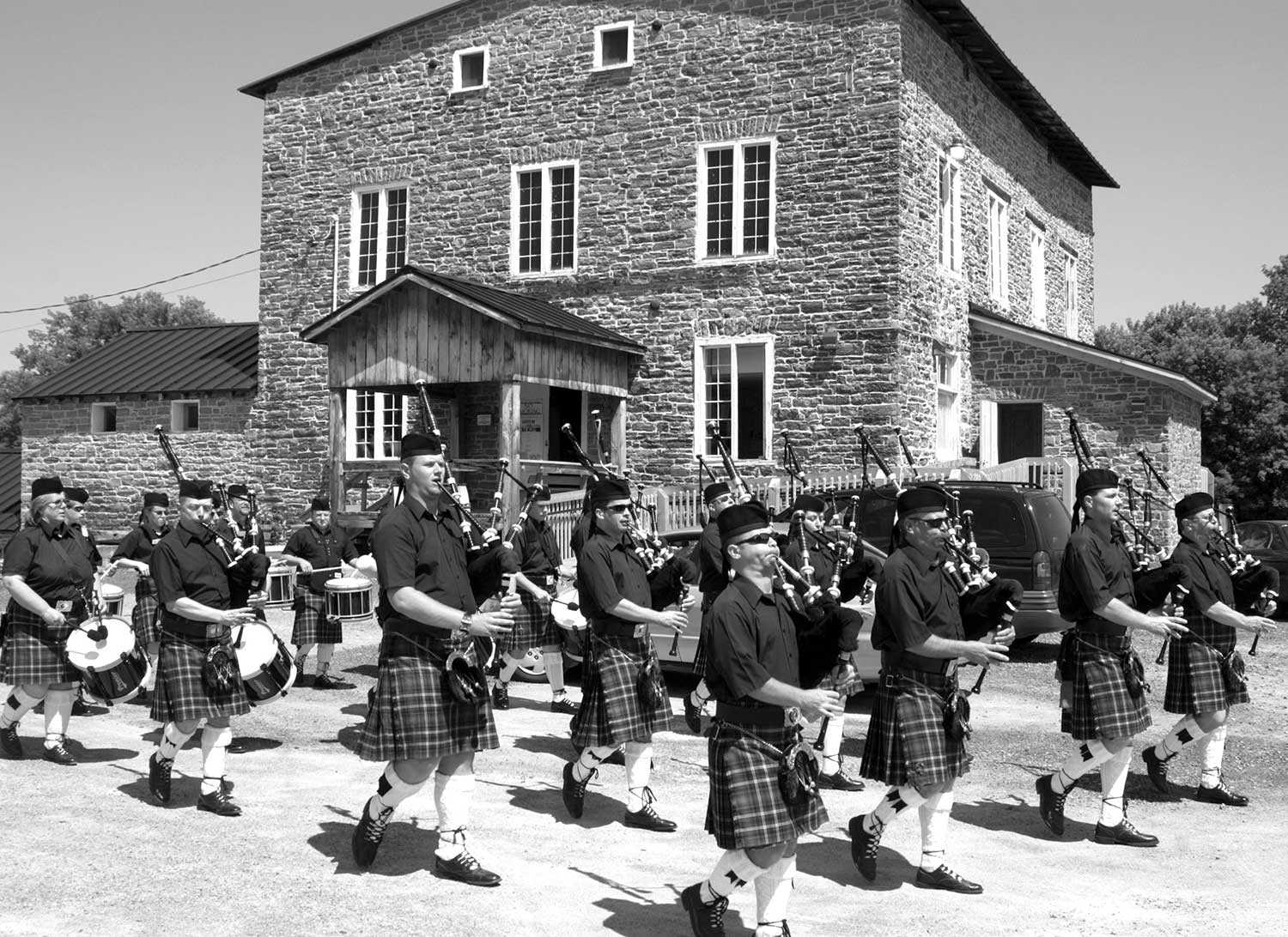 Parade du Glengarry Pipe Band dans la propriété du moulin de Spencerville (Photo : The Spencerville Mill Foundation)