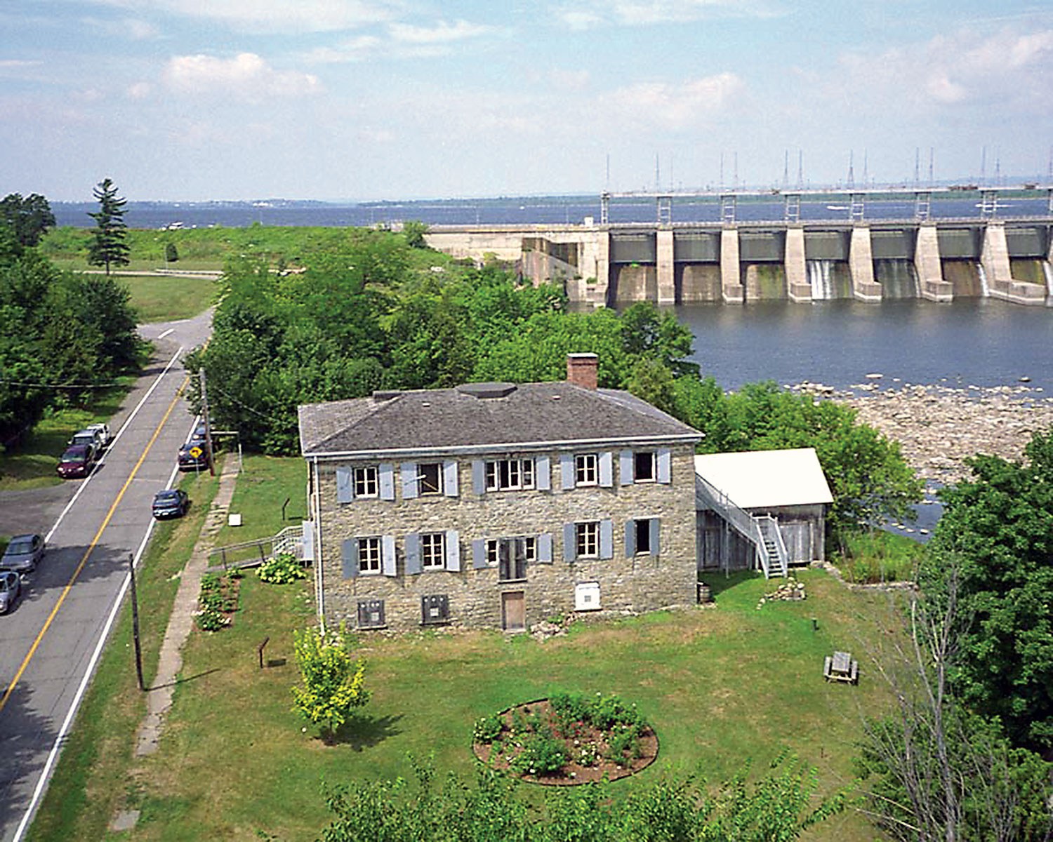 Photographie aérienne de la maison Macdonell-Williamson avec le barrage de Carillon à l’arrière-plan (Photo : Carl Bigras)