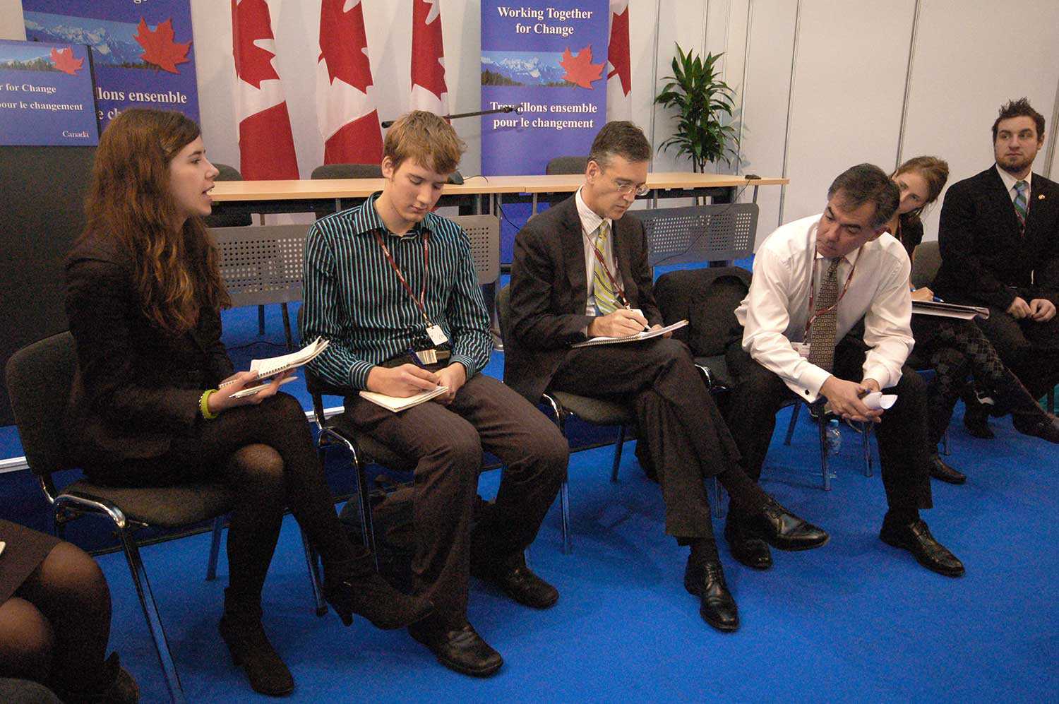 Meagan (à gauche) évoque la politique du Canada en matière de changement climatique avec le député Jim Prentice (troisième à droite) et les négociateurs canadiens, à l’occasion de la Convention-cadre des Nations Unies sur les changements climatiques de décembre 2008.