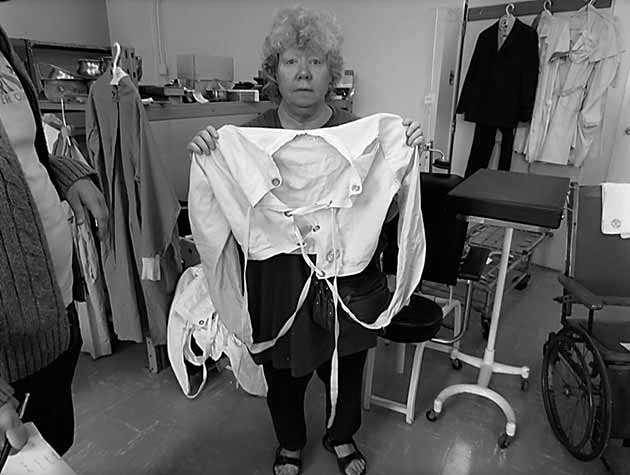 Pat Seth, principale demanderesse dans le recours collectif de la Huronie, montrant une camisole de force utilisée dans l’établissement. (Photo : Nancy Viva Davis)