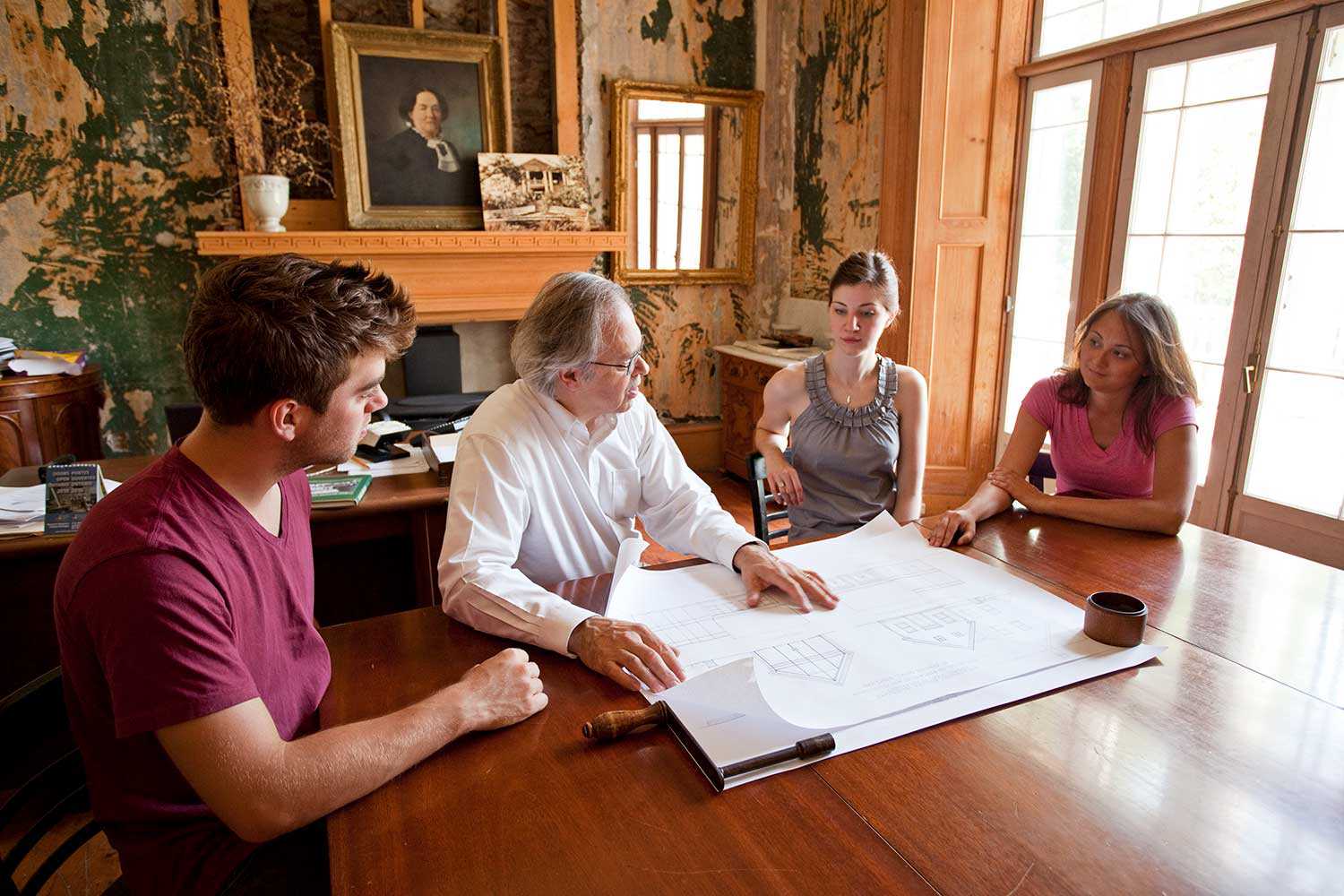 M. Julian Smith, directeur administratif, passe en revue les propositions de conception avec les  étudiants du programme de conservation du patrimoine (Photographie reproduite avec l’aimable autorisation de la Willowbank School of Restoration Arts)